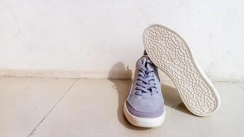 The gray sneakers on the floor Stock Photos