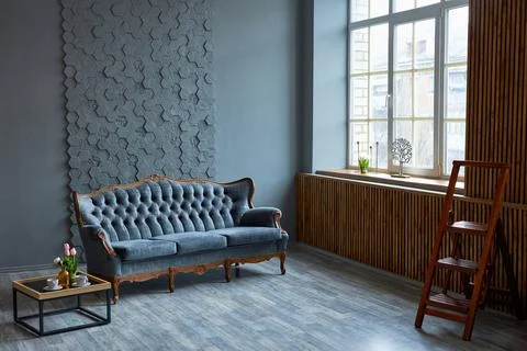 Gray sofa on a background of gray wall in classic livingroom Stock Photos