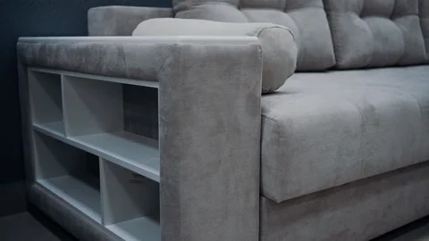 Gray sofa with decorative pillows. Sofa equipped with white side shelves. 4k Video stock 231508386