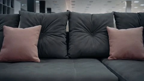 A gray sofa, shot close up, with gray and beige decorative pillows. Homedecor Video stock 235057366