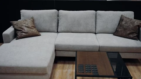 Gray sofa with two brown leather pillows. Black coffee table. 4k video. Stock Footage 231688709