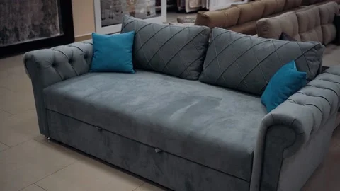 Gray sofa for two people with two blue decorative pillows. 4k video. Stock Footage 235057962