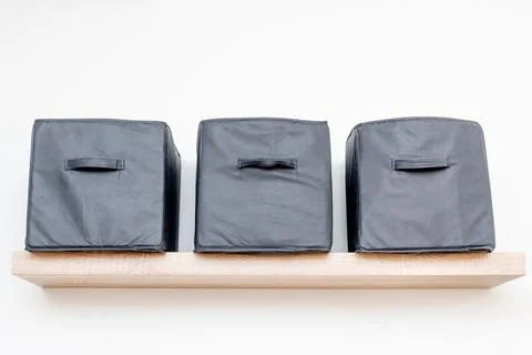 Gray square boxes for organizing space and storing things on shelf bedroom Stock Photos