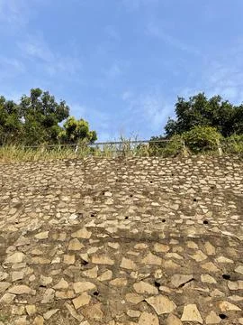 Gray stacked stone wall background. stacked stone walls to hold the cliff soil	 Stock Photos