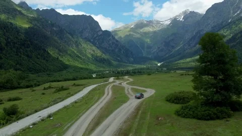 Gray station wagon moving on dirt road in mountain valley Video stock 301233328