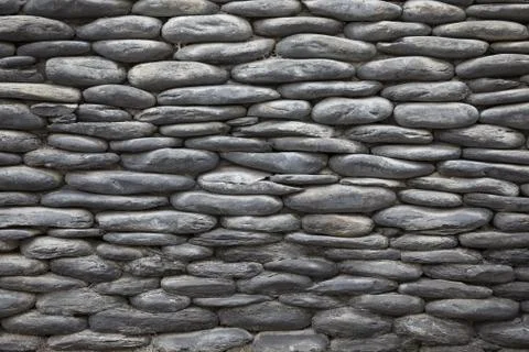 Gray stone background of the old wall of pebbles Stock Photos