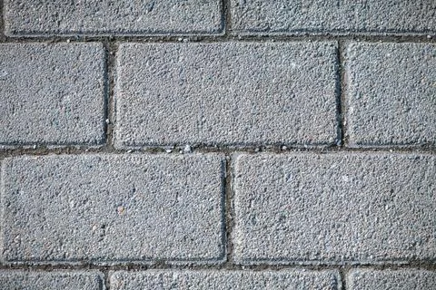Gray stone interlocking pavers create a structured and coarse surface, provid Stock Photos
