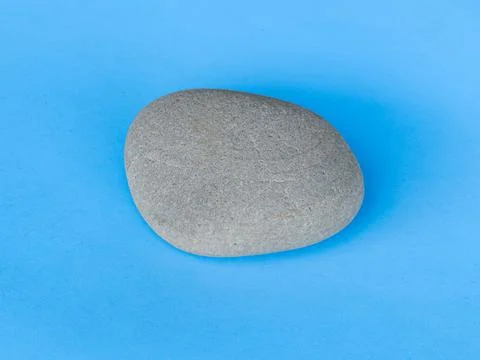 Gray stone isolated on blue Stock Photos