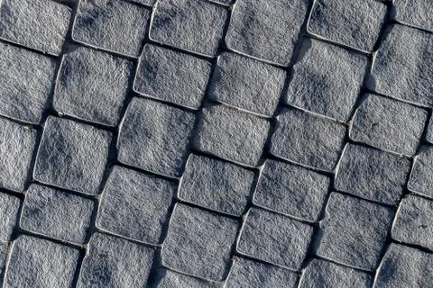 Gray stone paved footpath, diagonal direction with side light Stock Photos