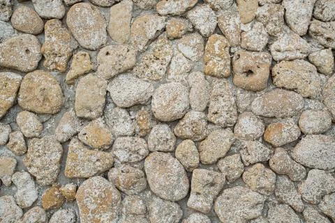 Gray stone wall background, rounded beige stones Stock Photos
