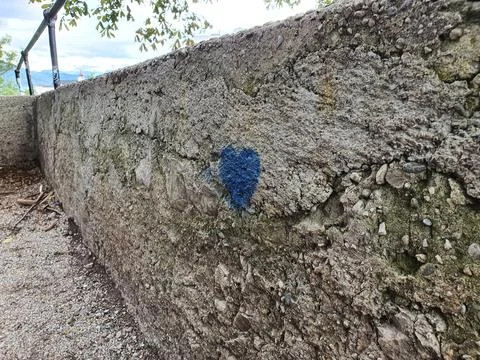 Gray stone wall blue heart. drawing blue heart on a grey stone Stock Photos