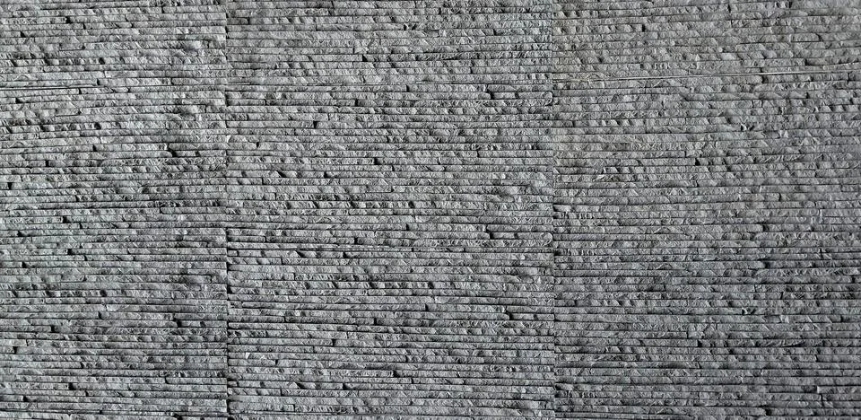 Gray stone wall texture background with narrow horizontal layered slate tiles. Stock Photos