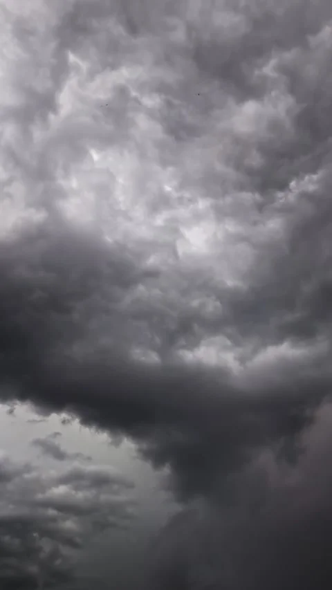 Gray storm clouds move across the sky, occasionally illuminated by flashes .. Stock Footage 280658011