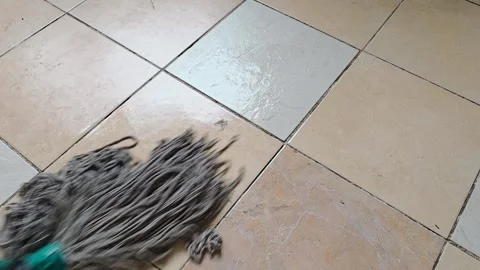 Gray string mop cleans across tiled flooring in a wiping motion, floor clea.. Stock Footage 343165898