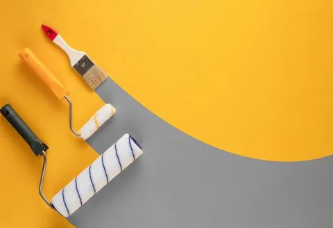 Gray stripes of paint from rollers and brushe on a yellow background. Stock Photos
