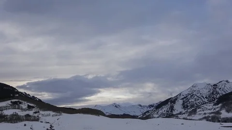 Gray sunset as clouds flow over mountain peaks timelapse Stock Footage 107693136