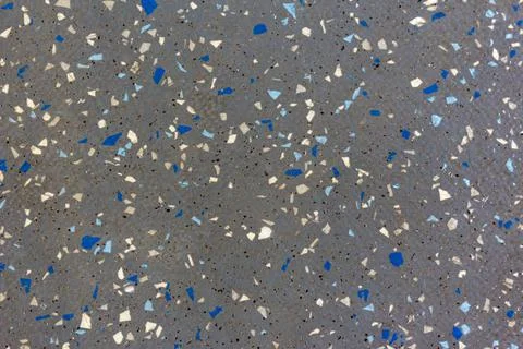 A gray surface with colored particles arranged randomly. Clusters of particles Stock Photos
