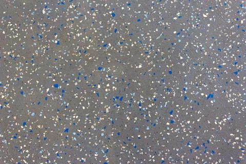 A gray surface with colored particles arranged randomly. Clusters of particles Stock Photos