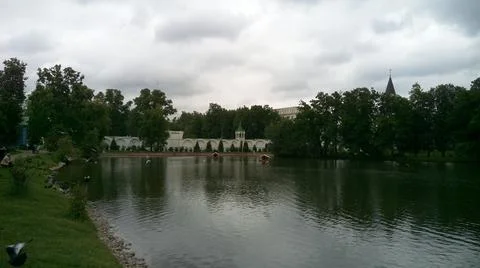 The gray surface of the lake with reflected clouds and white buildings hidden be Foto stock