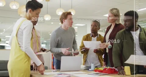 Gray-sweater man reaching and laying prints design team sorting swatches Stock Footage 331565614