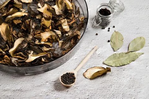 On a gray table, a drying dish with dried porcini mushrooms . The concept of Stock Photos