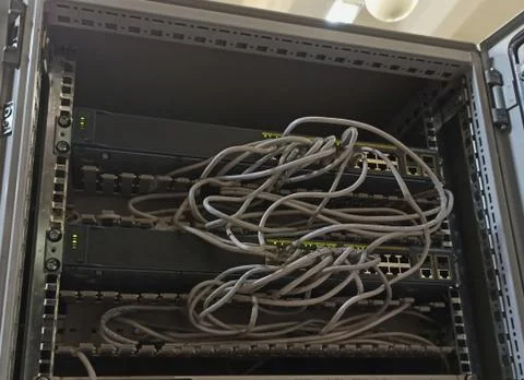 Gray tangled wires in the server room. A cobweb made of wires of the Internet. Stock Photos