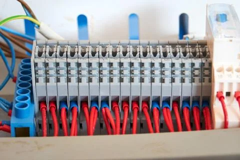Gray terminal block with connected red wires. Stock Photos