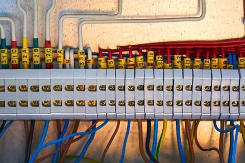 Gray terminal block with connected red wires. Stock Photos