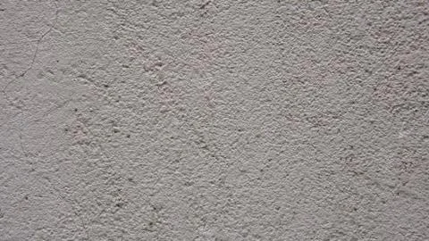 Gray texture of concrete wall of an old house with cracks. Decorative plaster Stock Photos