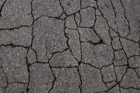 Gray texture of cracked asphalt for background Stock Photos