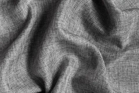 Gray textured fabric background with large folds. Stock Photos