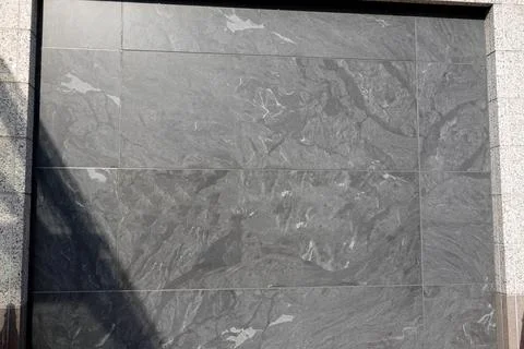 Gray textured flat Marble granite wall on the side of a building Stock Photos