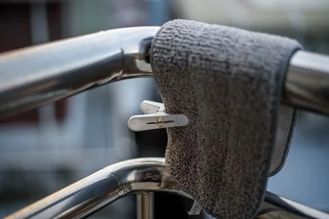 Gray, textured towel draped over a chrome metal railing with a small white .. Stock Photos