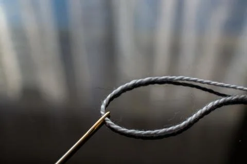 Gray Thread and Needle on the Table. Stock Photos
