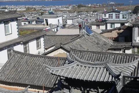 Gray tiled rooftops overlooking lakeside town and blue water Stockfoto's