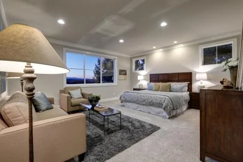 Gray tones bedroom interior with queen bed facing sitting area  Stock Photos