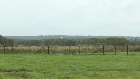 Gray training plane fly quickly and low above ground of aerodrome. Russian flag. Stock Footage 118677439
