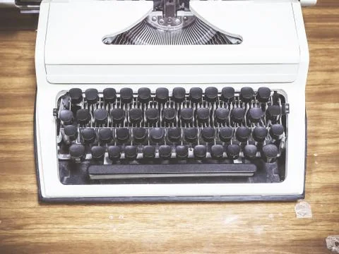 A gray typewriter with black keys without letters stands on a wooden table Stock Photos