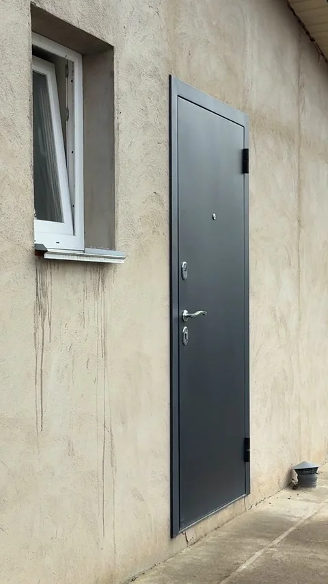 Gray unfinished house construction plaster walls iron doors small window spring Stock Footage 345847990