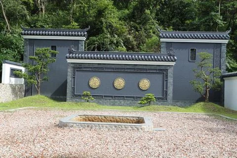 A gray wall with three round gold carvings on the front, surrounded by grav.. Stock Photos