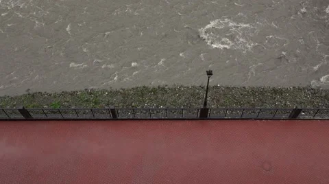 Gray water stream rush beside red tiled pavement, empty promenade Mzymta river Video stock 67236559