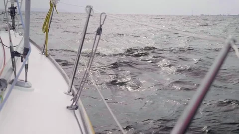 Gray waves break against the side of white sailing yacht Stock Footage