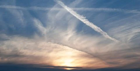 Gray, white and orange clouds in the blue sky at dawn Stock Photos