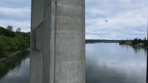Gray white bridge pillars and cloud reflection over dark blue water Stock Footage 154812990