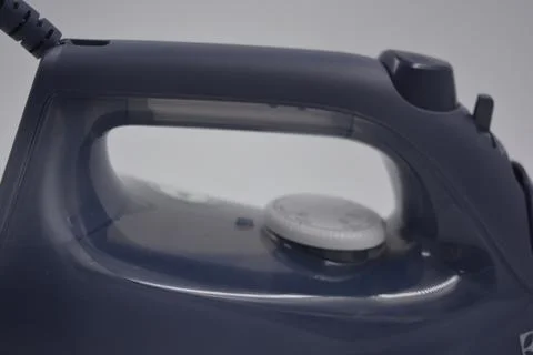 Gray white plastic iron with sprayer, metal bottom is on a white plastic. Stockfoto's