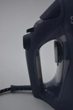 Gray white plastic iron with sprayer, metal bottom is on a white plastic. Stockfoto's