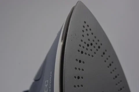 Gray white plastic iron with sprayer, metal bottom is on a white plastic. Stockfoto's