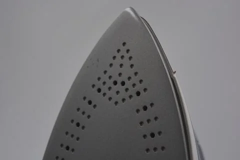 Gray white plastic iron with sprayer, metal bottom is on a white plastic. Stockfoto's