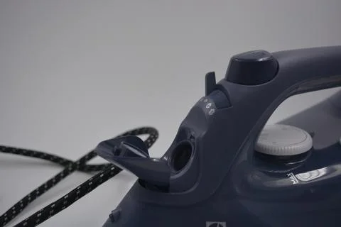 Gray white plastic iron with sprayer, metal bottom is on a white plastic. Foto stock