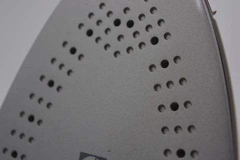 Gray white plastic iron with sprayer, metal bottom is on a white plastic. Stockfoto's